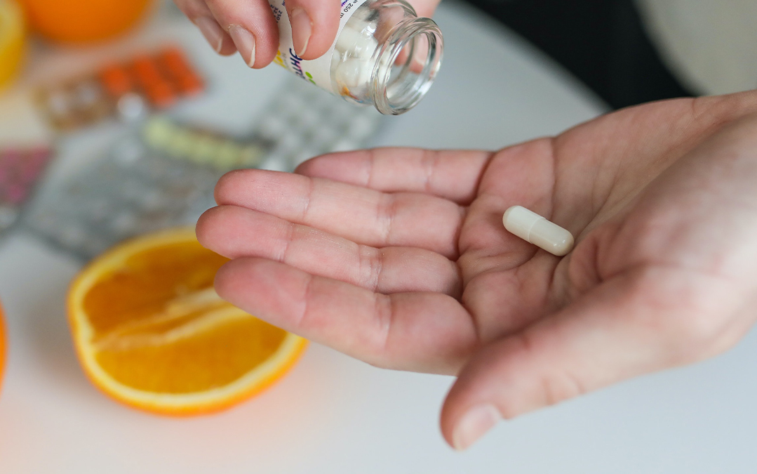 Persons hand with a vitamin tablet