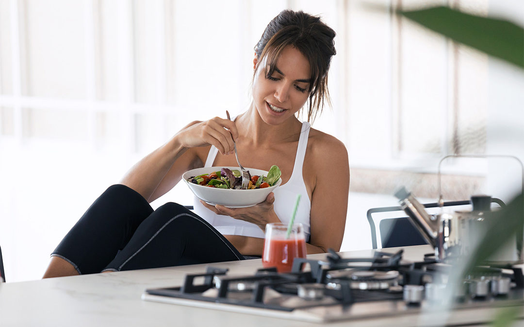 Woman eating a salad in the kitchen